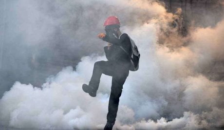A demonstrator kicks a tear gas canister back to the riot police during an anti-government protest in Ankara