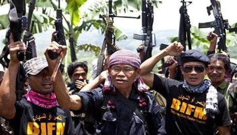 Moro Islamic Liberation Front rogue commander Ustadz Ameril Umbra Kato and his followers raise their weapons as they chant slogans after a clandestine news conference in Maguindanao