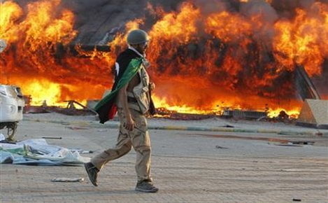 A Libyan rebel walks in the Bab Al-Aziziya compound in Tripoli