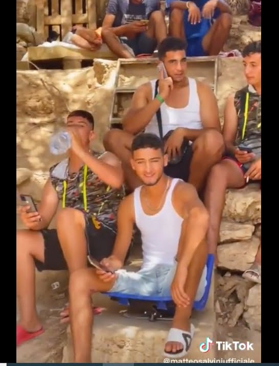 migranri a Lampedusa con smartphone