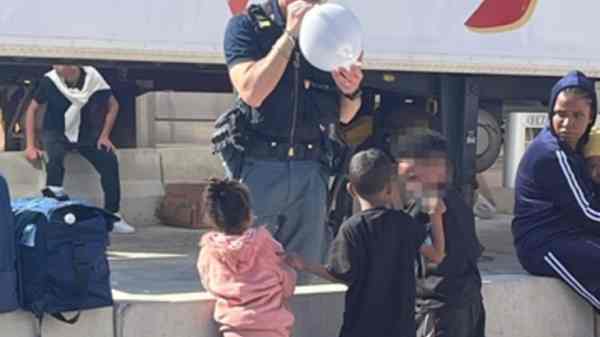 Lampedusa, poliziotto regala palloncini a bambini migranti Lampedusa, poliziotto regala palloncini a bambini migranti